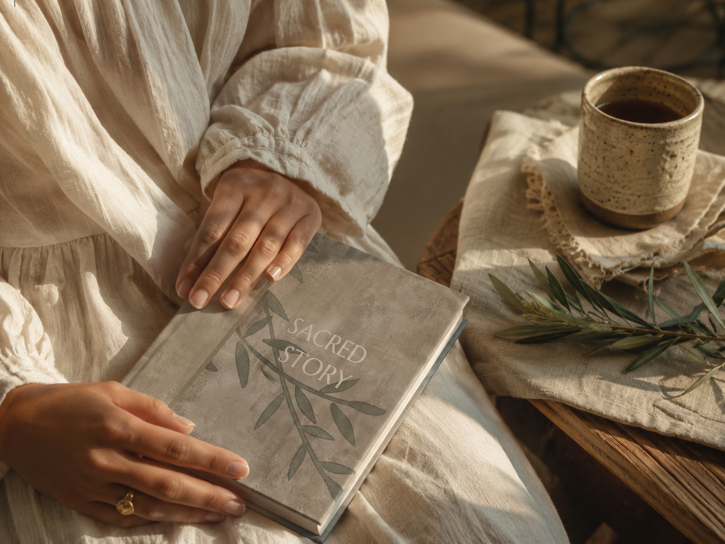 A reader holding the Olive edition of Sacred Story in soft natural light.